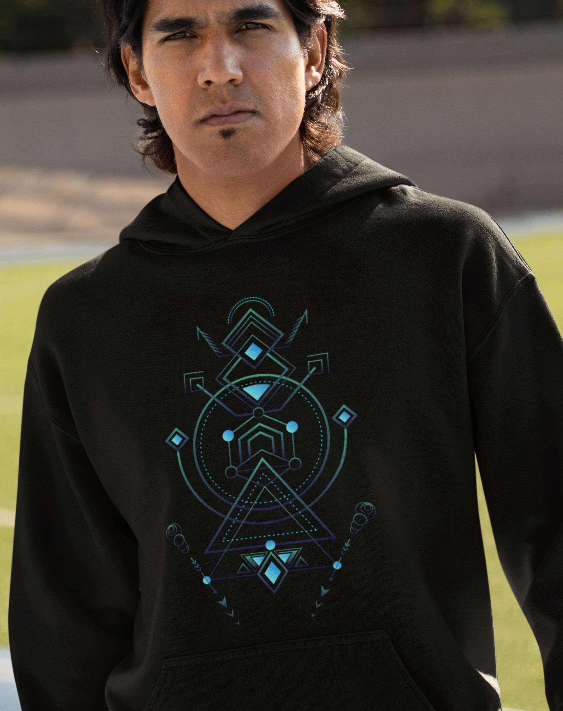 Man wearing a black t-shirt with a geometric design on a beach