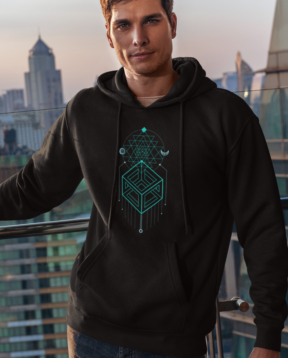 Person wearing a black hoodie with a geometric design in teal, standing on a balcony with cityscape background