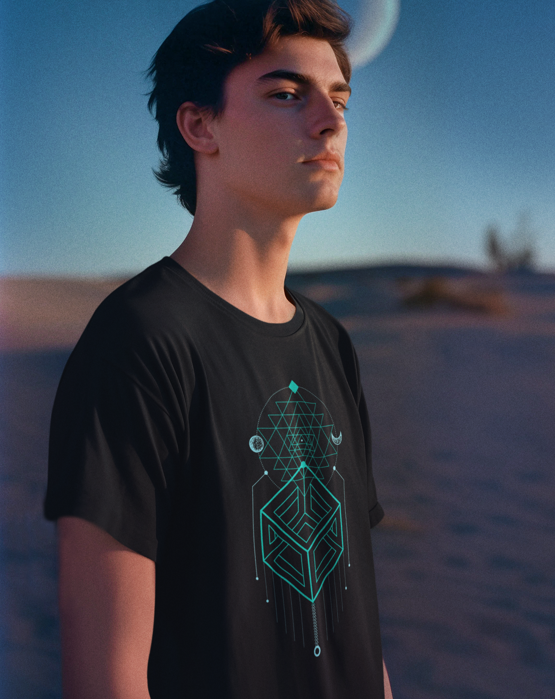 Person wearing a black t-shirt with a geometric design in a desert setting